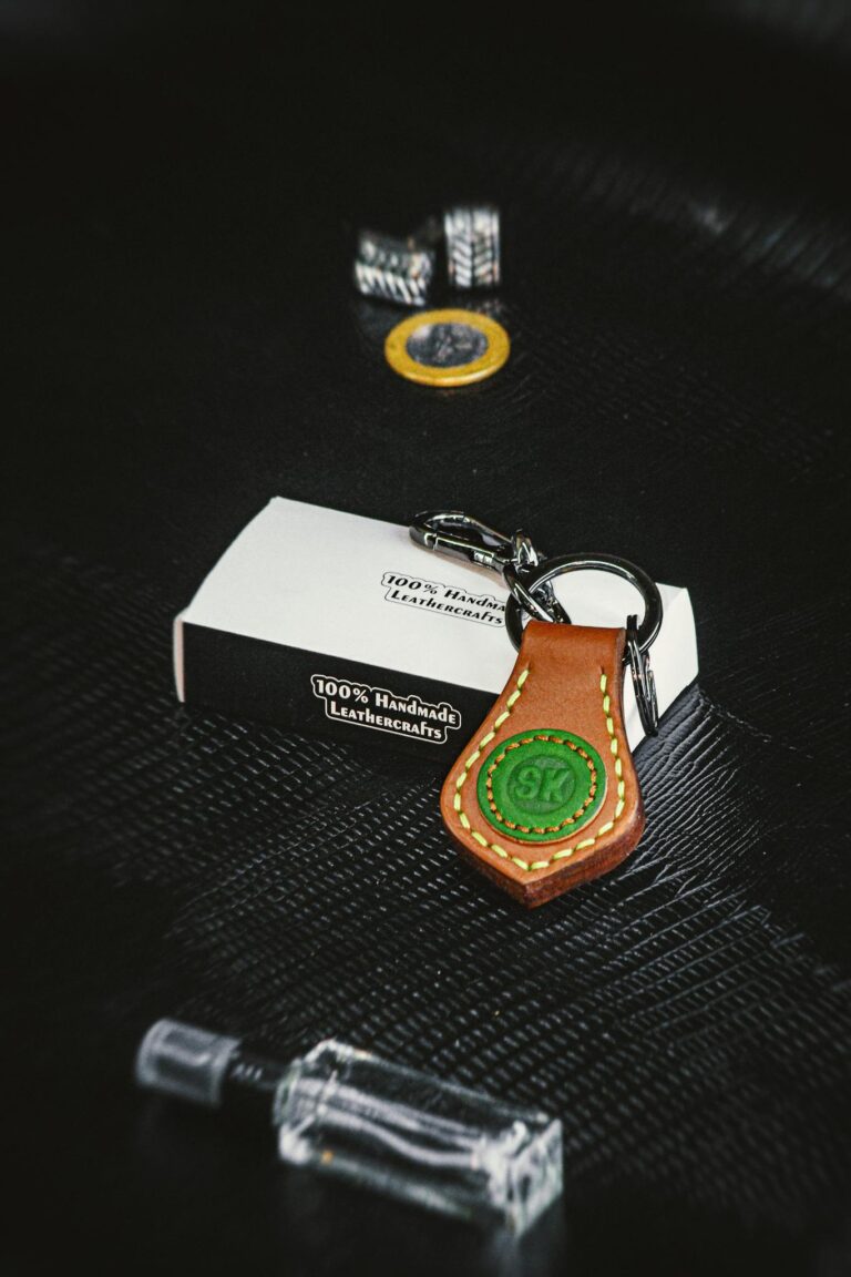 Close-up of a handcrafted leather keychain on textured black background, embodying style and craftsmanship.