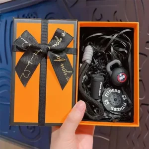Fitness keychain gift set with kettlebell, weight plate and shaker bottle charms in an orange gift box with black bow