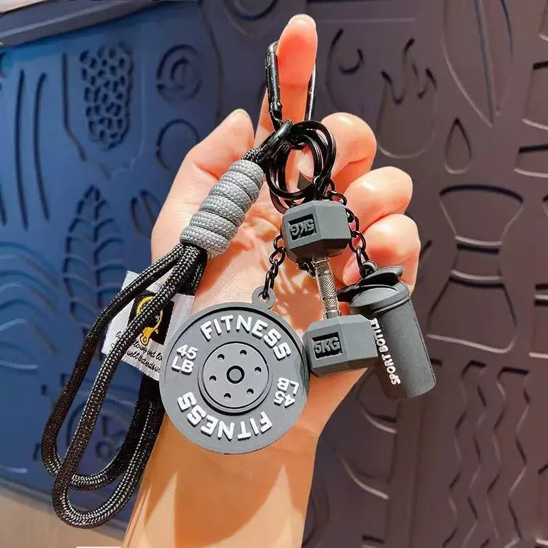Grey fitness keychain set with FITNESS weight plate, 5 kg dumbbell and sport bottle charms on a black strap