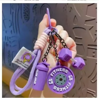Purple fitness keychain set with weight plate, dumbbell and sport bottle charms on a purple strap